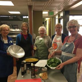 Group of five people smiling for the camera during a cooking class at the age well center.