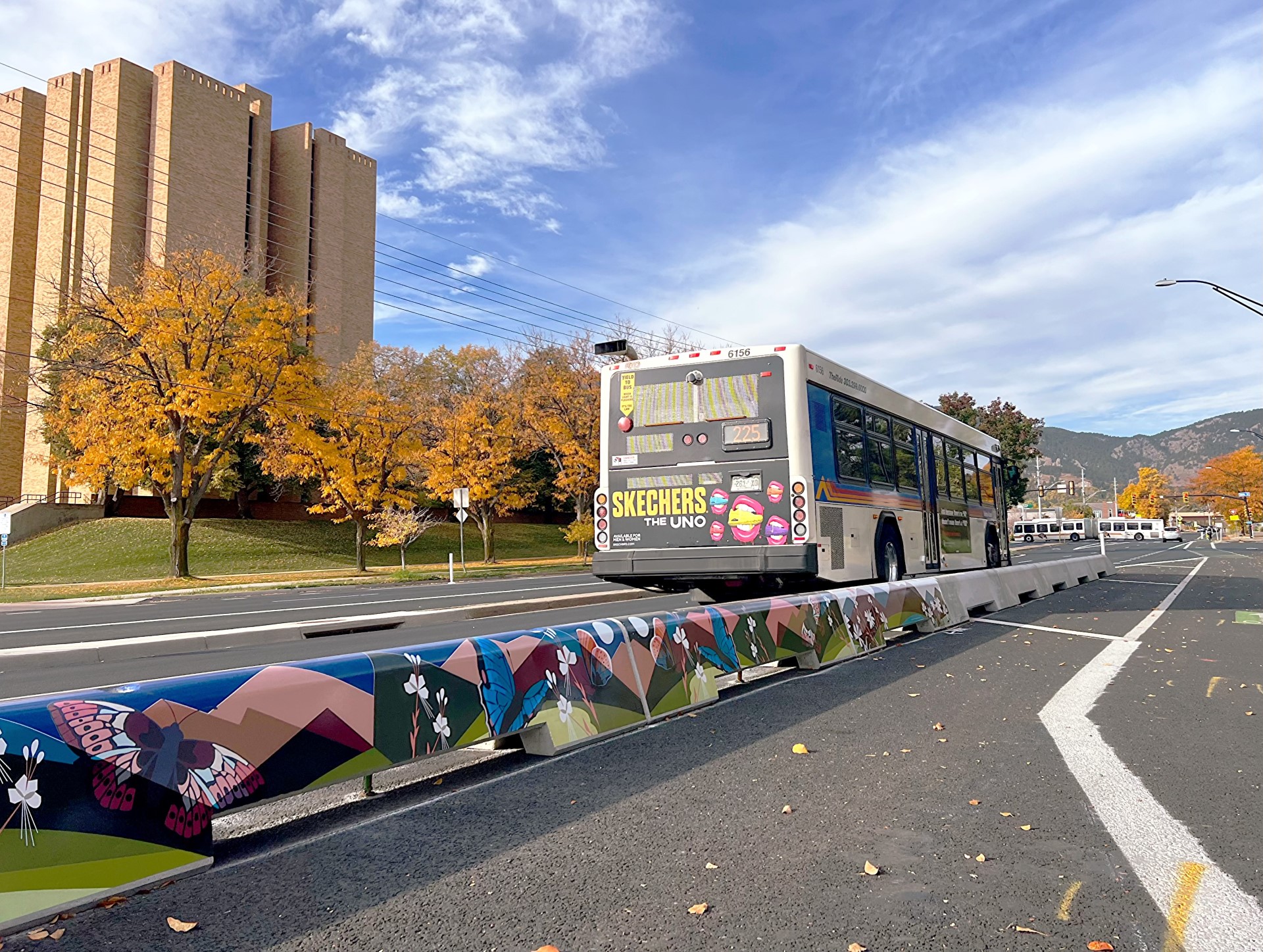 Bus along Baseline Road in the fall next to a concrete-tall-curb protected bike lane